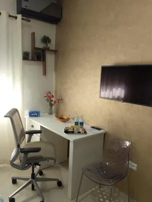 a desk with two chairs and a television on a wall at TheHive Residence in Fès