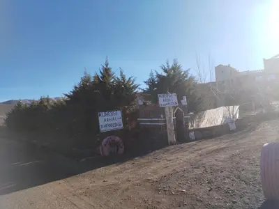 a fence with signs on the side of a road at auberge arhal lac tislit in Bou Tarhbalout