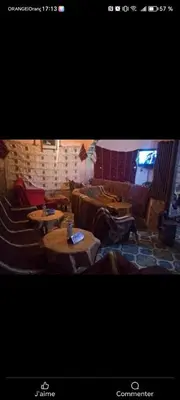 a living room with tables and couches in a room at auberge arhal lac tislit in Bou Tarhbalout