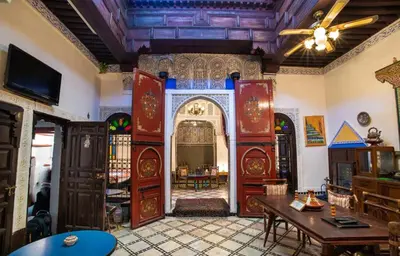 a living room with a table and a ceiling at Fes Antique Hostel in Fès