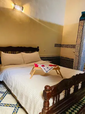 a bedroom with a bed with a table on it at Fes Antique Hostel in Fès