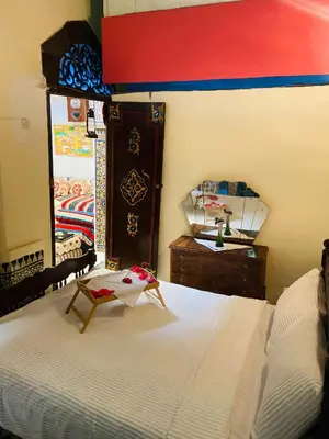 a bedroom with a bed and a dresser and a mirror at Fes Antique Hostel in Fès
