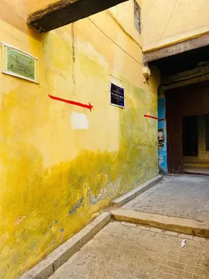 a yellow wall with two red arrows on it at Fes Antique Hostel in Fès