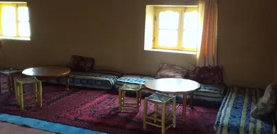 a living room with two tables and a couch at Sahara Desert Activites in Merzouga