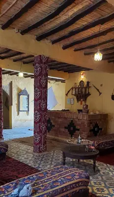a living room with a table in a room at hostel sable dor merzouga in Merzouga