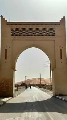 an archway in the middle of a road at hostel sable dor merzouga in Merzouga