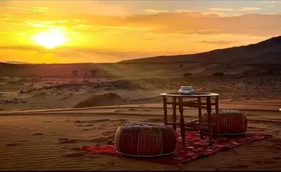 a table in the middle of the desert with two luggage at jumeirah resort luxury desert camp in Merzouga