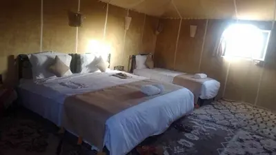 a hotel room with two beds and a window at jumeirah resort luxury desert camp in Merzouga