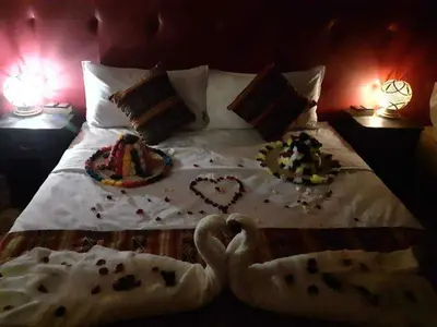 a bed with two plates of food on it at jumeirah resort luxury desert camp in Merzouga
