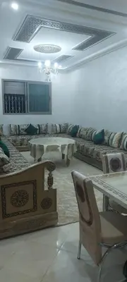 a living room with a table and a chair at Superbe appartement de luxe in Fès