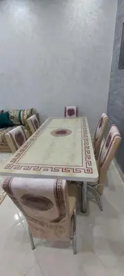 a table and chairs in a room with a table at Superbe appartement de luxe in Fès
