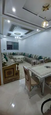 a living room with a table and a couch at Superbe appartement de luxe in Fès