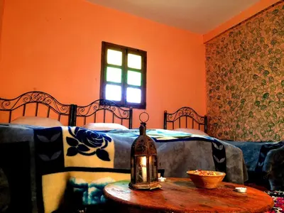 a bedroom with a bed and a table with a table sidx sidx sidx at Gite entre les deux vallées in Tacheddirt