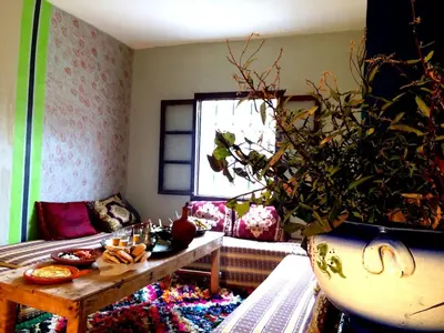 a living room with a table and a plant at Gite entre les deux vallées in Tacheddirt