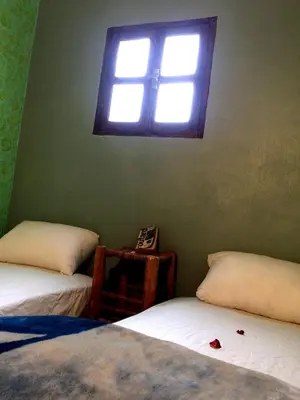 a bedroom with two beds and a window at Gite entre les deux vallées in Tacheddirt