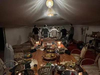 a group of people standing around a table in a tent at Across Sahara in Bou Nou