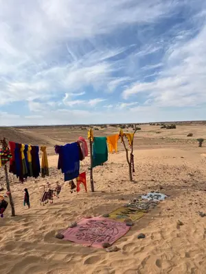 a beach with clothes hanging in the sand at Across Sahara in Bou Nou