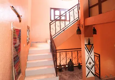 a staircase in a home with orange walls at Drâa Oasis House Palm Apartment in Ourhiz