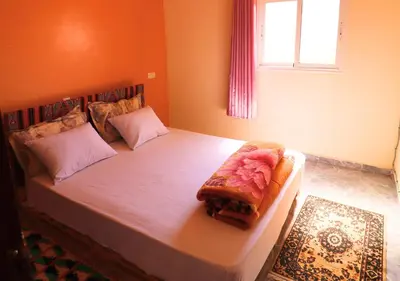 a bedroom with a large bed in a room at Drâa Oasis House Palm Apartment in Ourhiz