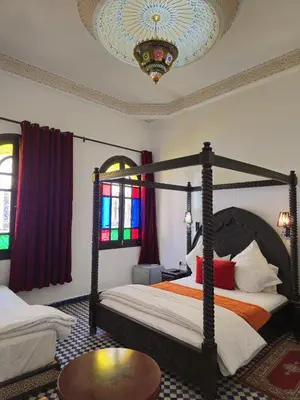 a bedroom with two beds and a chandelier at Riad Fes Bab Rcif Suite &Spa in Fès