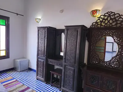 a bedroom with wooden furniture and a mirror at Riad Fes Bab Rcif Suite &Spa in Fès