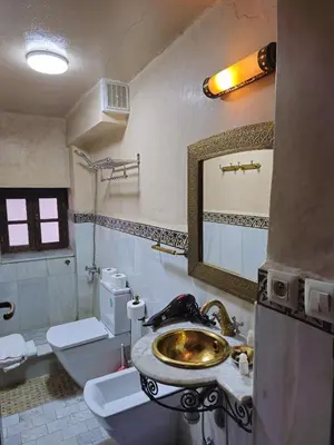 a bathroom with a sink and a toilet and a mirror at Riad Fes Bab Rcif Suite &Spa in Fès