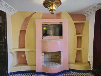 a living room with a fireplace with a tv at Riad Fes Bab Rcif Suite &Spa in Fès