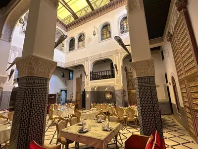 a restaurant with tables and chairs in a building at Riad Fes Bab Rcif Suite &Spa in Fès