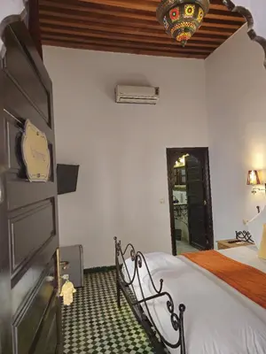 a bedroom with a bed and a chandelier at Riad Fes Bab Rcif Suite &Spa in Fès