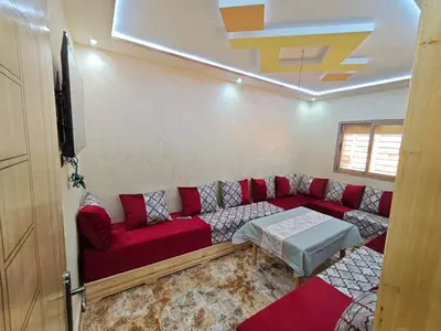 a living room with a red couch and a tv at Dar Ines in Midelt