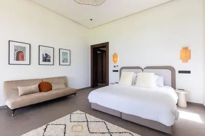 a white bedroom with a bed and a couch at Villa Dar Tillili Marrakech in Heddad
