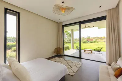 a bedroom with a bed and a sliding glass door at Villa Dar Tillili Marrakech in Heddad