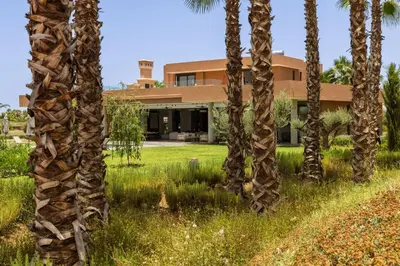 a house with palm trees in front of it at Villa Dar Tillili Marrakech in Heddad