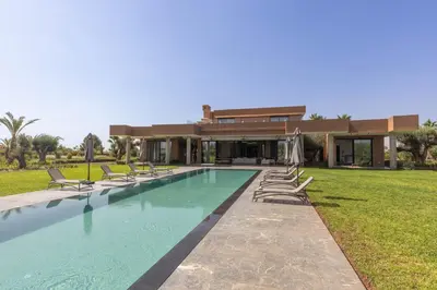 a house with a swimming pool in front of a house at Villa Dar Tillili Marrakech in Heddad