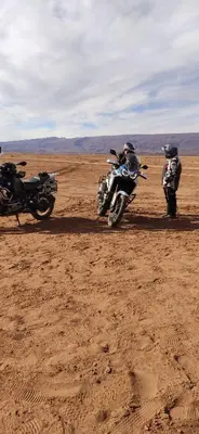 two people riding motorcycles in the desert at auberge lac iriki in Foum Zguid
