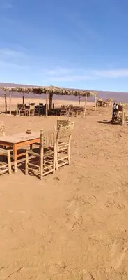 a group of tables and chairs on the beach at auberge lac iriki in Foum Zguid