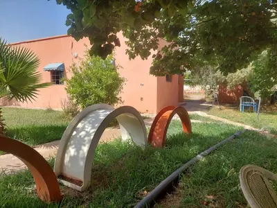 a group ofulptures in the grass in front of a building at Ferme Amzrou in Had Abdallah Rhiat