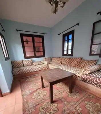 a living room with a couch and a table at Ferme Amzrou in Had Abdallah Rhiat