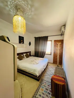 a bedroom with a bed and a chandelier at Riad Dades Canyon in Akedim Msemrir