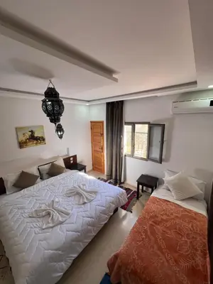 a bedroom with two beds and a window at Riad Dades Canyon in Akedim Msemrir