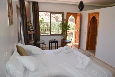 a large white bed in a room with a window at Riad Dades Canyon in Akedim Msemrir
