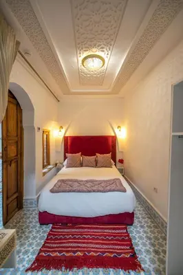 a bedroom with a large bed with a red headboard at Dar Mima in Fès