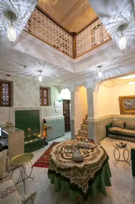 a living room with a table and a couch at Dar Mima in Fès