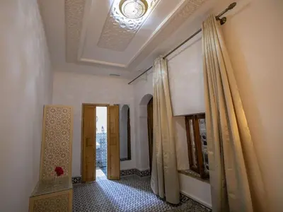a hallway with doors and curtains in a building at Dar Mima in Fès