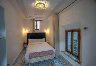 a bedroom with a large bed and a window at Dar Mima in Fès