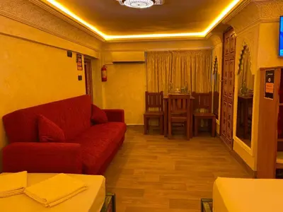 a living room with a red couch and a table at Entire place Medina's Home in Fès