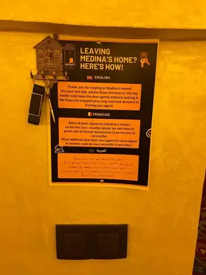 a sign on a yellow door with a house on it at Entire place Medina's Home in Fès