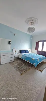 a bedroom with a bed and a dresser at Bel appartement familial au centre ville in El Kelaa des Srarhna