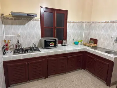 a kitchen with a counter top with a microwave at Bel appartement familial au centre ville in El Kelaa des Srarhna