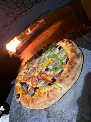 a pizza is being cooked in an oven at Bel appartement familial au centre ville in El Kelaa des Srarhna